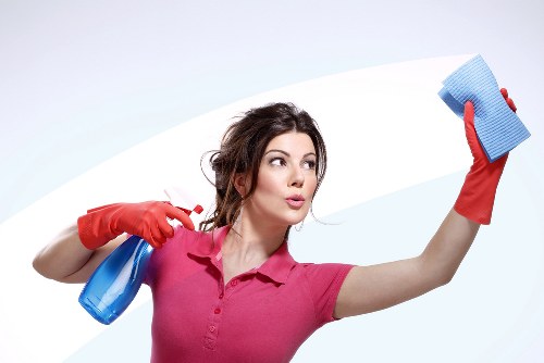 Technician using upholstery cleaning equipment on a sofa